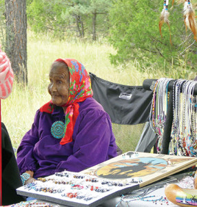 An elderly craftswoman enjoys displaying her own work along with that of other family members