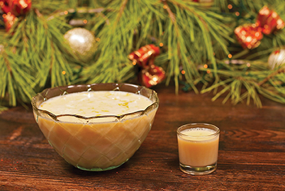 15882196 - bowl of eggnogg served agianst festive decoration background
